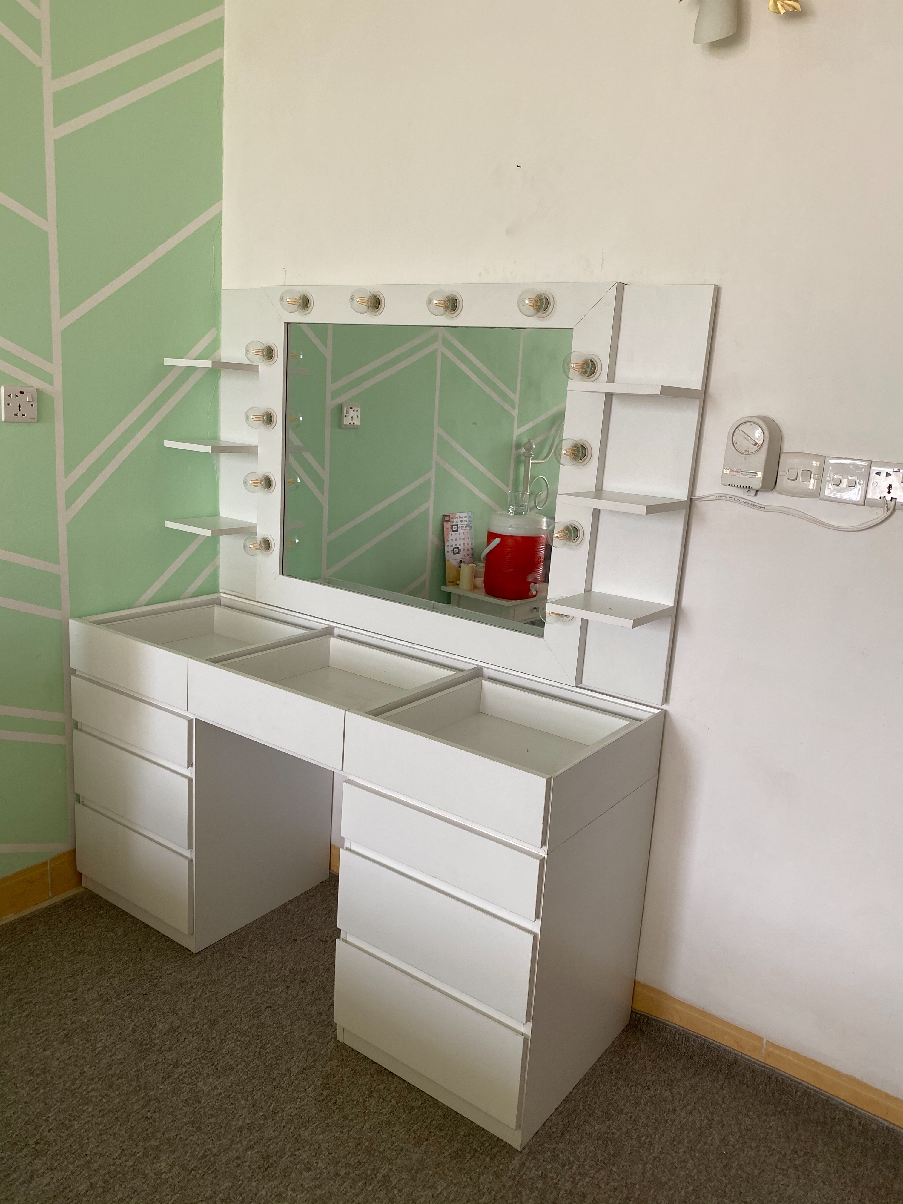 Built-in vanity with lighted mirror and open shelving