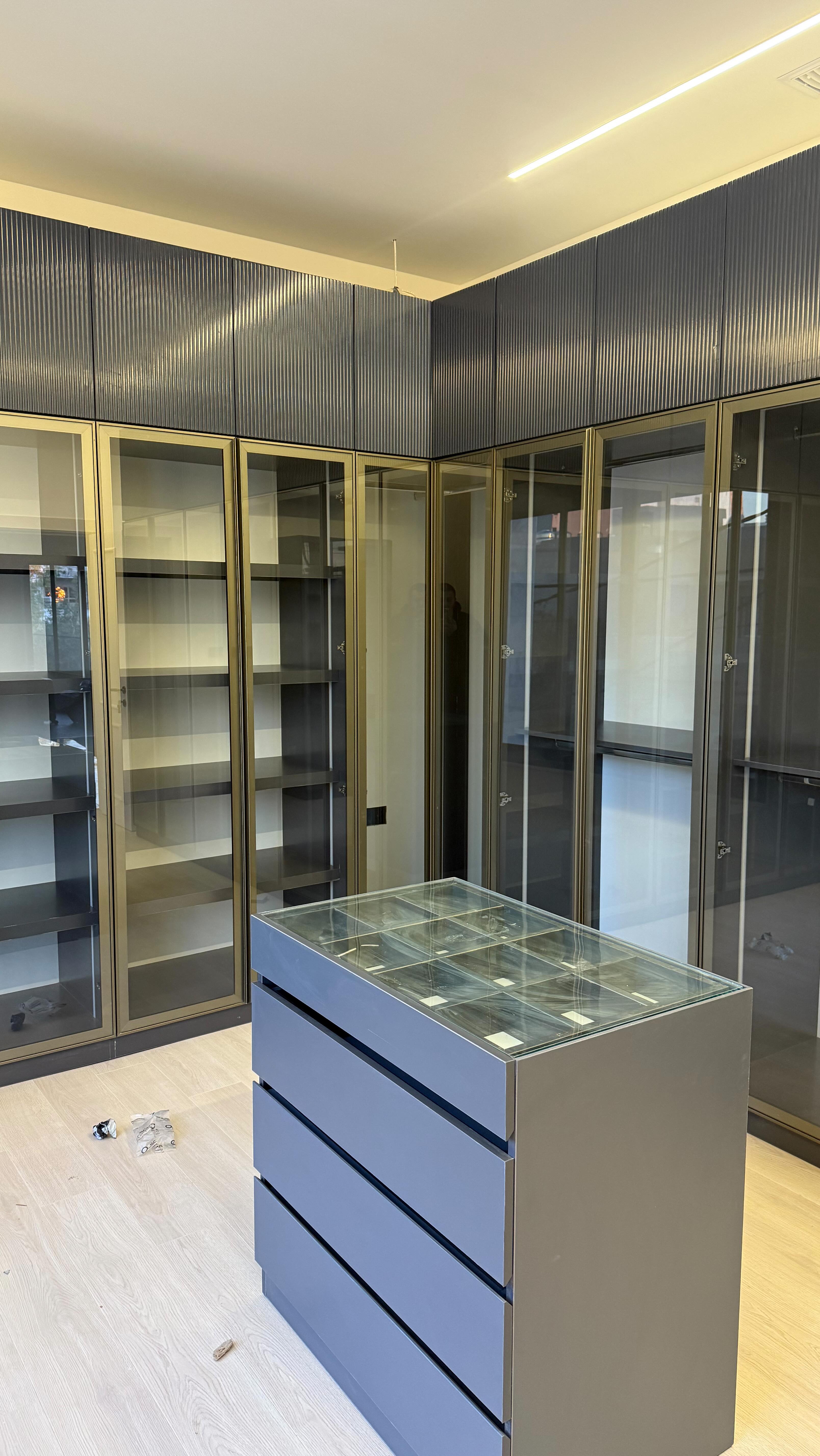 Full walk-in wardrobe — glazed doors and a glass-top island